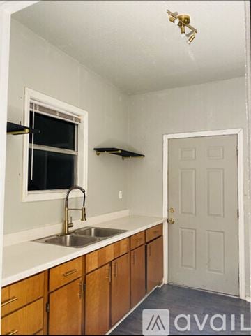 San Antonio house for rent - A kitchen with wooden cabinets and a white sink.