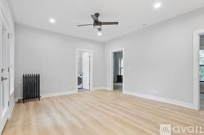 Chicago apartment for rent - A spacious room with a ceiling fan and lighting fixtures.