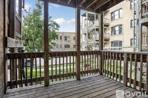 Chicago apartment for rent - A wooden deck with a view of a grassy area and apartment buildings.