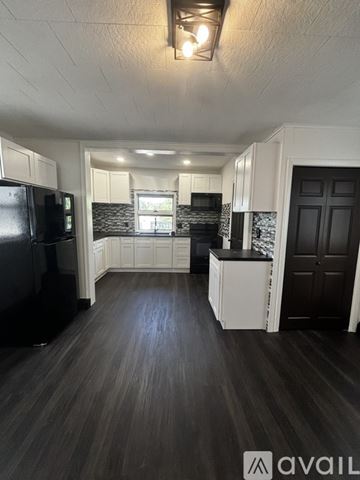 Schuylkill Haven house for rent - A kitchen with black appliances and white cabinets.