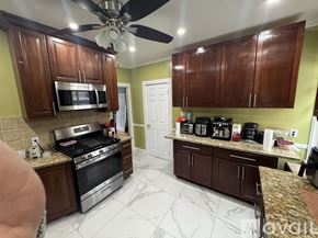 Boston house for rent - A kitchen with a stove, oven, microwave, and a fan.