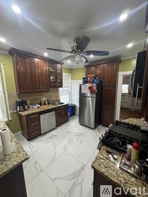 Boston house for rent - A bathroom with a toilet, sink, and mirror.