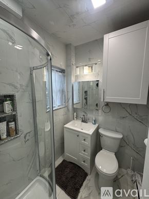Boston house for rent - A bedroom with a bed, desk, and two windows.