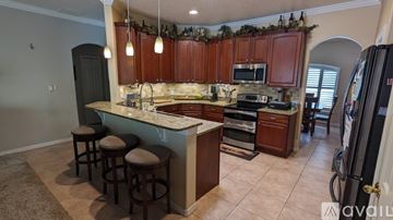 Deltona house for rent - A kitchen with brown cabinets and a marble countertop.