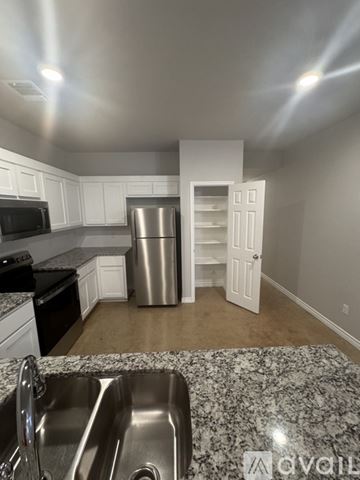 Harker Heights apartment for rent - A kitchen with a stainless steel refrigerator and a granite countertop.