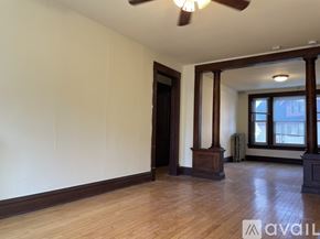 Madison apartment for rent - A room with a wooden floor and a white wall with a door and a table with chairs.