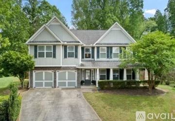 Kennesaw house for rent - A two-story house with a garage is surrounded by trees.