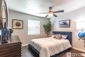 Dallas apartment for rent - A large outdoor swimming pool surrounded by a grassy area and trees.