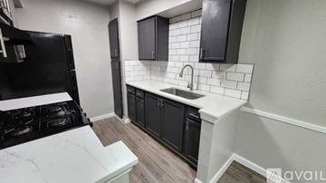 Dallas apartment for rent - A kitchen with black cabinets and a white countertop.