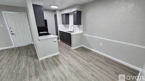 Dallas apartment for rent - A room with a white door and a kitchenette with a sink and stove.
