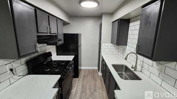 Dallas apartment for rent - A kitchen with black cabinets and a white countertop.