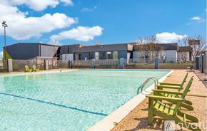 Dallas apartment for rent - A large outdoor swimming pool surrounded by a grassy area and trees.