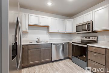 Rapid City apartment for rent - A kitchen with white cabinets and a stainless steel refrigerator.
