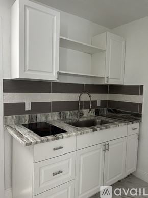 Bradenton apartment for rent - A kitchen with white cabinets and a marble countertop.