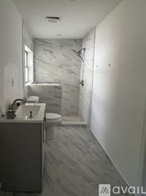 Bradenton apartment for rent - A bathroom with a marble tile floor and walls.