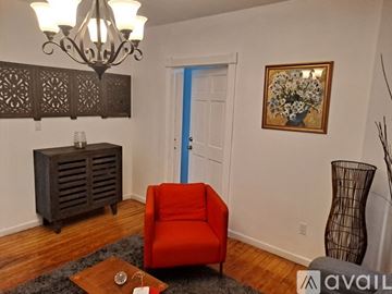 Mount Vernon apartment for rent - A living room with a red chair and a chandelier.