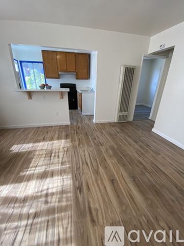 Berkeley apartment for rent - A room with wooden flooring and a window with brown cabinets.