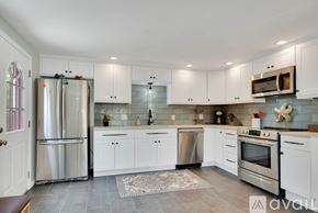 Old Saybrook house for rent - A kitchen with white cabinets and stainless steel appliances.
