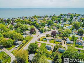 Old Saybrook house for rent - A bird's eye view of a residential area with houses, trees, and a road.