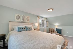 Old Saybrook house for rent - A bedroom with a large bed and a chair.