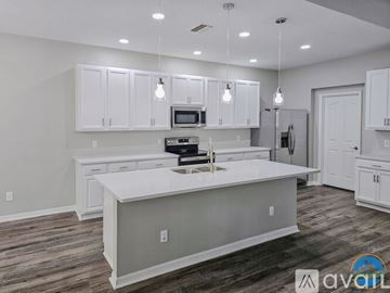 Riverview house for rent - A modern kitchen with white cabinets and a central island.