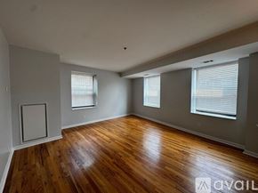 Chicago apartment for rent - A room with wooden floors and two windows.
