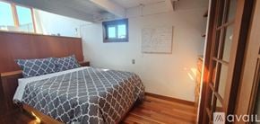 Sausalito house for rent - A wooden bedroom with a bed, desk, and chair.