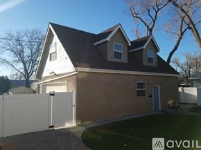 Pueblo apartment for rent - A house with a white fence in front of it.