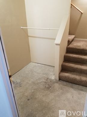 Pueblo apartment for rent - A staircase with a carpeted runner and a white handrail.