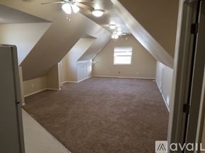 Pueblo apartment for rent - A room with a carpeted floor and a window with a white frame.