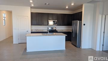 Tucson house for rent - A kitchen with a white island and black cabinets.