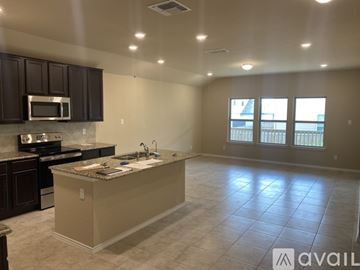 New Braunfels house for rent - A kitchen with a granite countertop and a microwave above it.