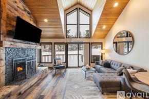 Bigfork townhouse for rent - A modern living room with a fireplace and a large window.
