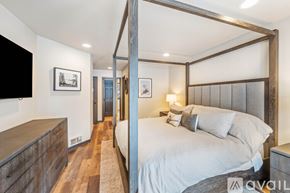Bigfork townhouse for rent - A bedroom with a four poster bed and a wooden dresser.