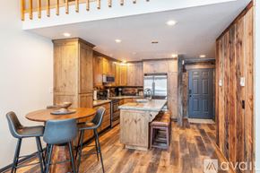 Bigfork townhouse for rent - A kitchen with wooden cabinets and a table with chairs.