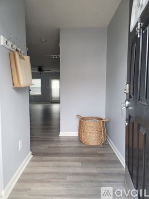 Raleigh townhouse for rent - A hallway with a basket on the floor and a black door on the right.