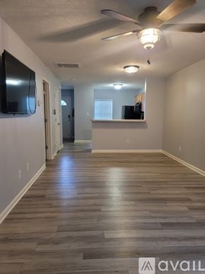 Raleigh townhouse for rent - A spacious room with wooden flooring and a ceiling fan.