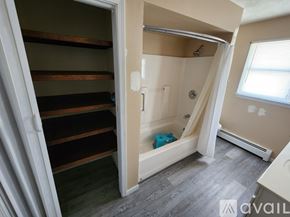 Mesick apartment for rent - A bathroom with a walk-in shower and a wooden shelving unit.