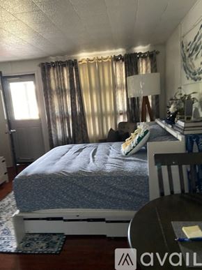 Broadalbin apartment for rent - A bedroom with a bed, a chair, and a lamp.