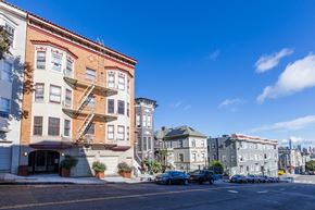 San Francisco apartment for rent - A street view of a residential area with buildings and parked cars.