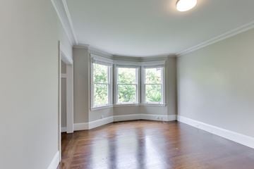 San Francisco apartment for rent - A room with a wooden floor and a window with a view of trees.