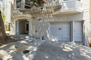 San Francisco apartment for rent - A white building with a balcony and a sign on the wall.