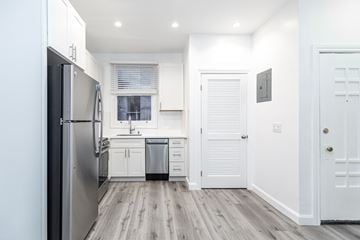 San Francisco apartment for rent - A kitchen with white cabinets and a stainless steel refrigerator.