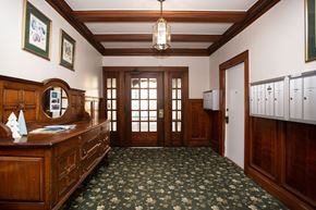 San Francisco apartment for rent - A hallway with a wooden floor and ceiling, a chandelier, and a row of lockers on the right.