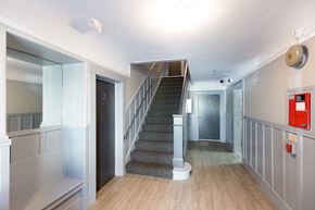 San Francisco apartment for rent - A staircase with a grey carpeted runner and a wooden handrail.