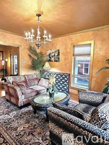 Coeur D'alene house for rent - A living room with a leopard print chair and a chandelier.
