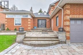 Markham (Unionville) house for rent - A red brick house with a black door and a stone walkway leading to it.