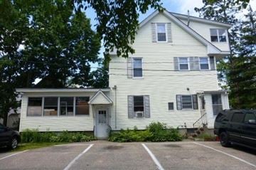 Laconia apartment for rent - A two-story house with a white exterior and a grey roof.