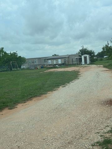 Clyde house for rent - A gravel road leads to a house and a small shed.