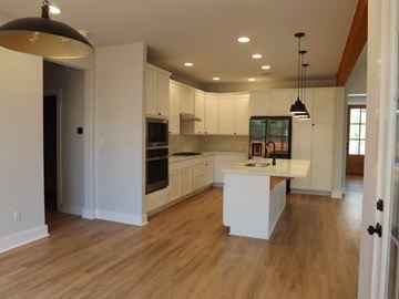 Granite Shoals house for rent - A kitchen with white cabinets and a wooden floor.